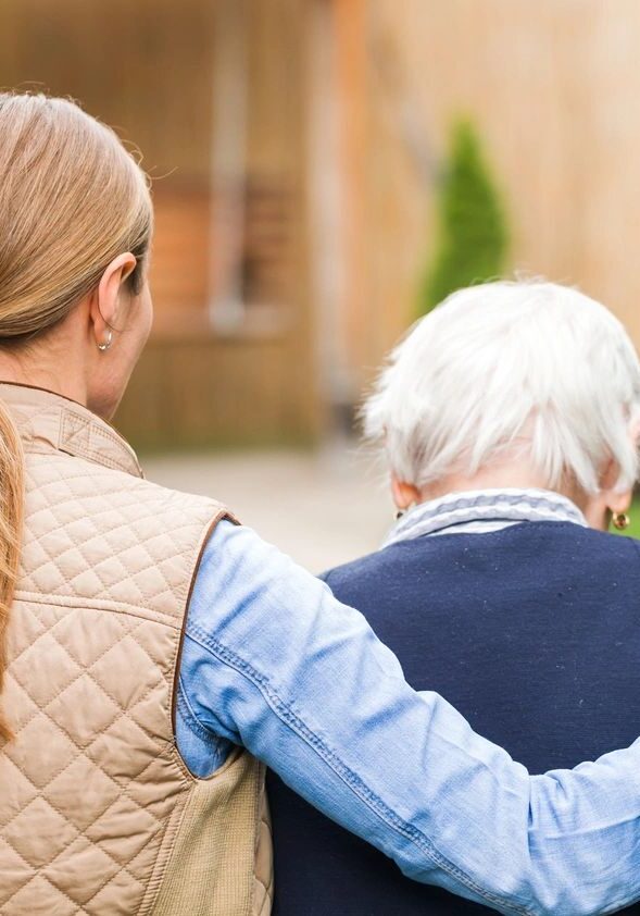 A woman and an old man are standing outside